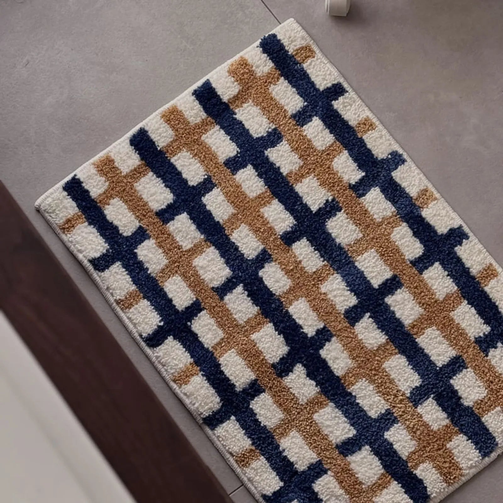 Full flat lay view of the rectangular plaid accent rug on grey tile - RoomDen