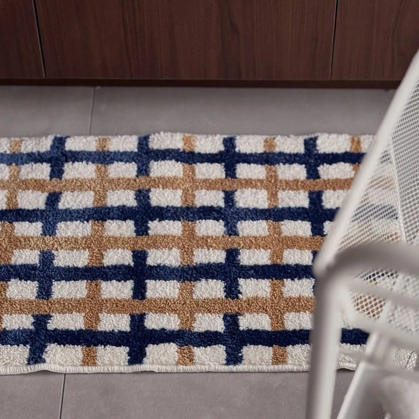 Wide horizontal shot of the navy and tan grid rug on the floor - RoomDen