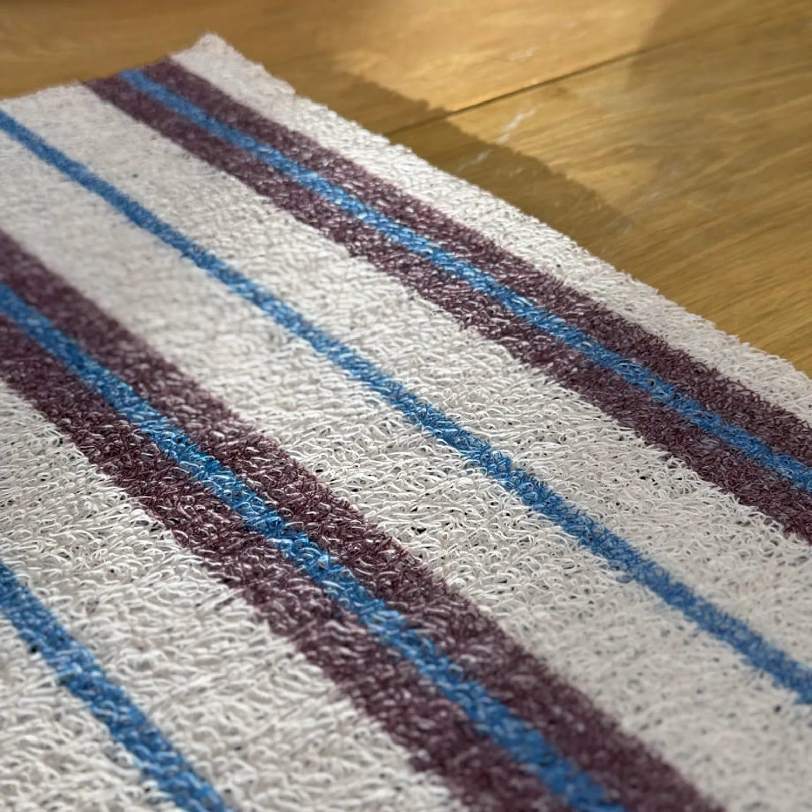 Close-up texture shot of the white PVC loops showing the blue and purple stripe detail.