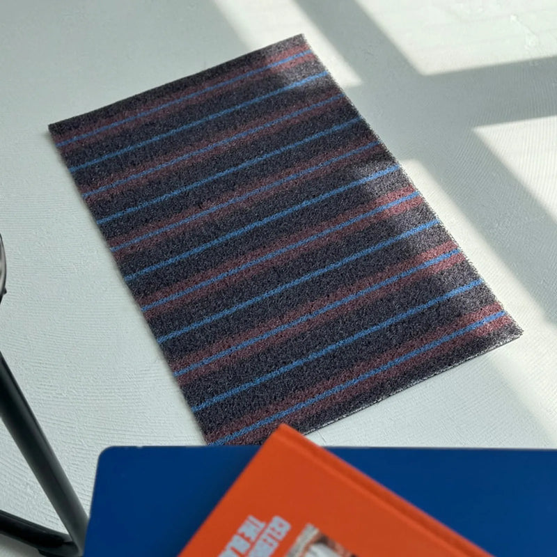 Shadow grey PVC coil rug with pinstripes on a white concrete floor - RoomDen