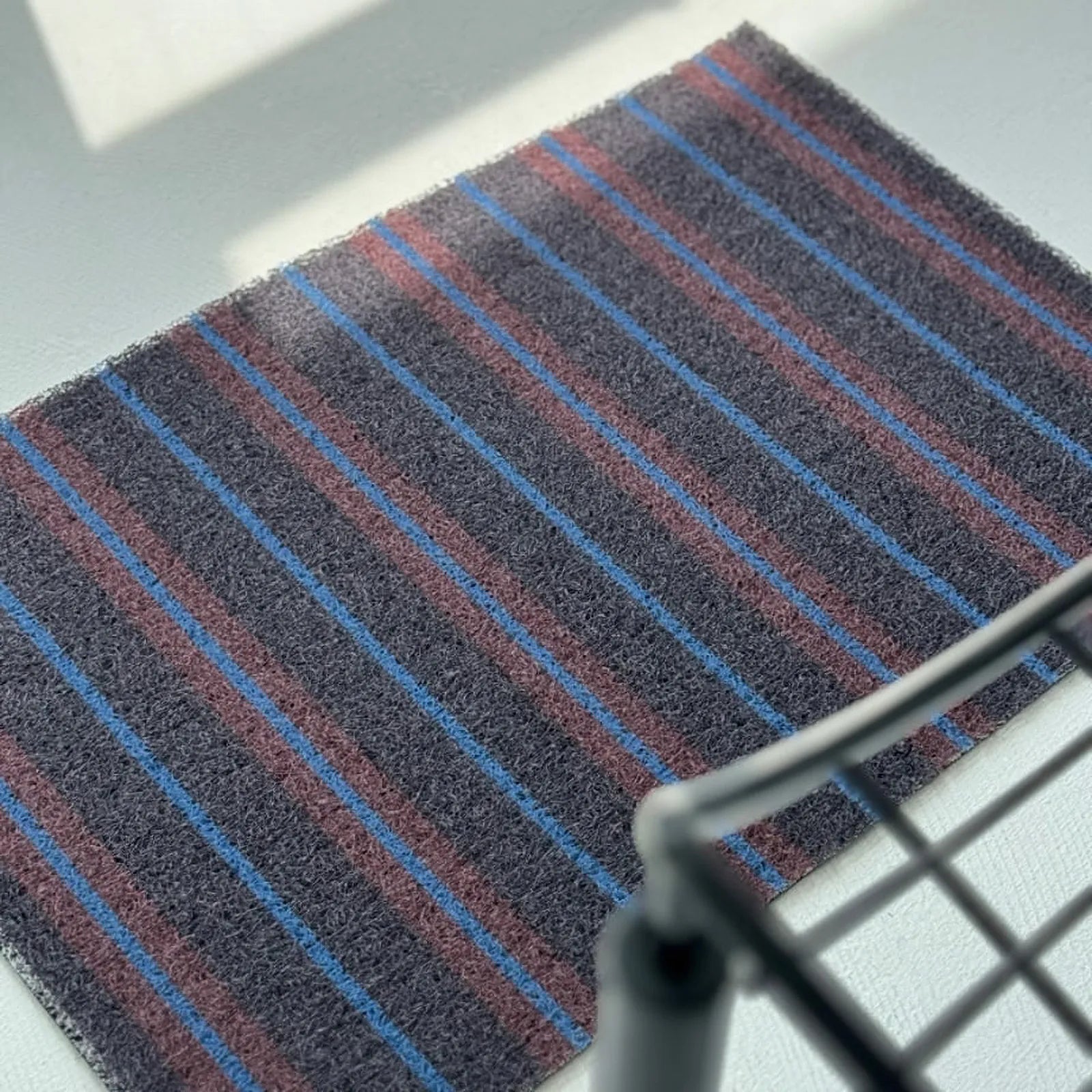 Close-up detail of the dark grey coil texture with blue and purple lines.