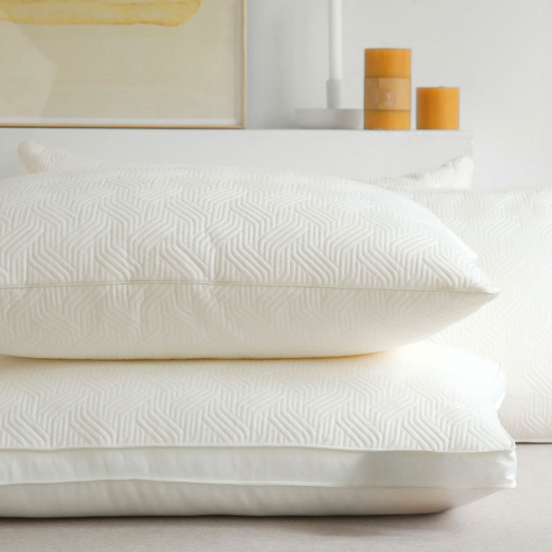 Plant-based down alternative pillow inserts styled on beige bed with rattan nightstand and amber glass - RoomDen