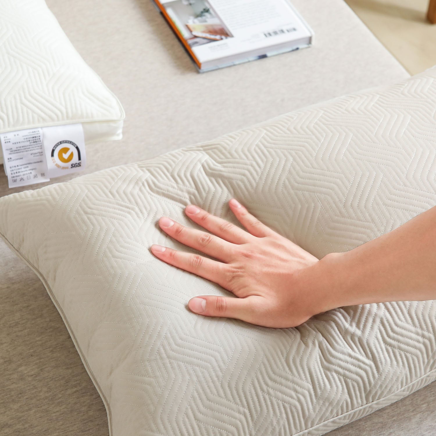 Hand pressing plant-based pillow insert to show soft, resilient support - RoomDen 