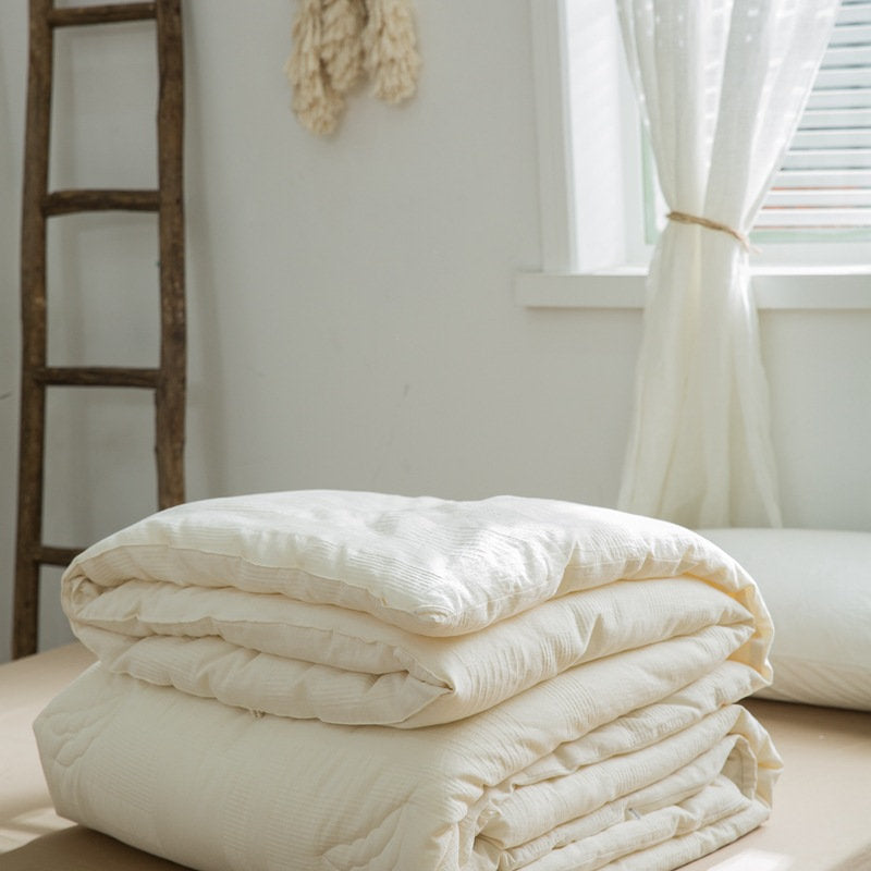Layered plant-based down alternative insert folded on beige sheet - RoomDen