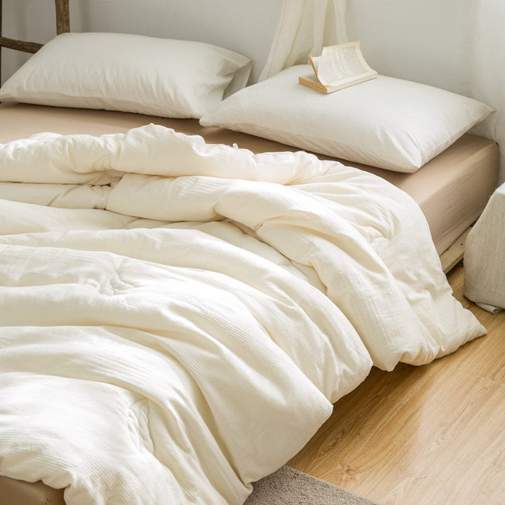 Plant-Based Down Alternative Duvet Insert on minimal wooden bed frame in bright neutral bedroom - RoomDen