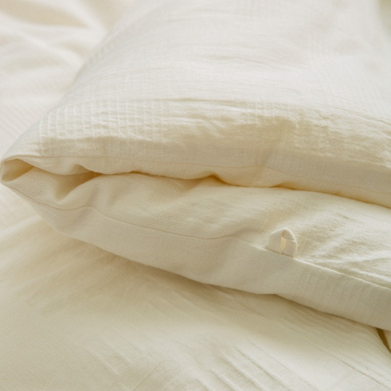 Close-up of folded plant-based duvet insert showing smooth cotton texture - RoomDen