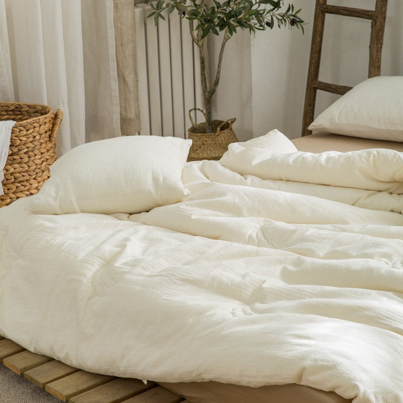 Fluffy eco-friendly duvet insert casually draped on bed corner - RoomDen