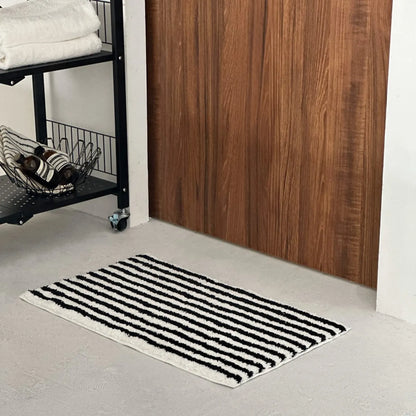 Black irregular stripe rug in a modern entryway setting - RoomDen