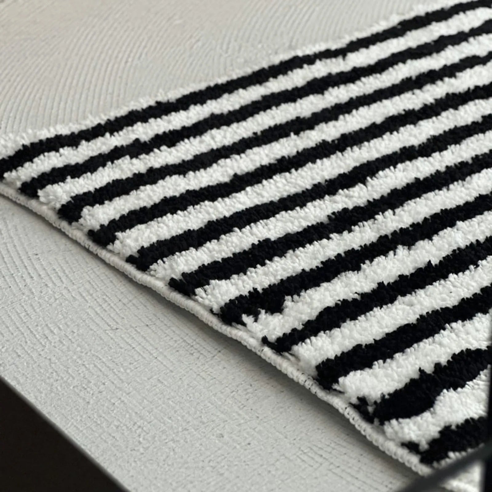 Close up texture of black and white tufted rug edge - RoomDen