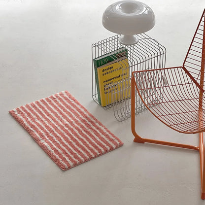 High angle view of pink irregular stripe accent rug in a minimalist room - RoomDen