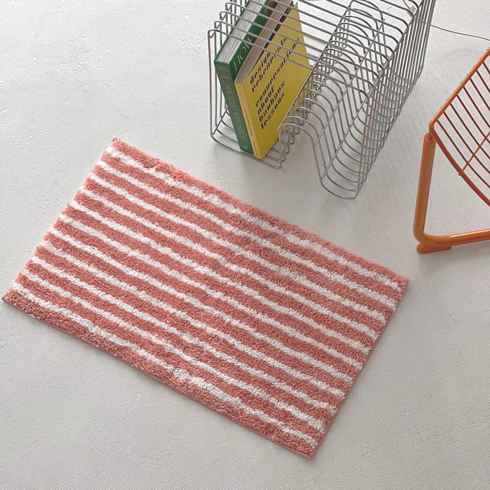 Top down shot of fluffy pink and white striped rug on white floor - RoomDen