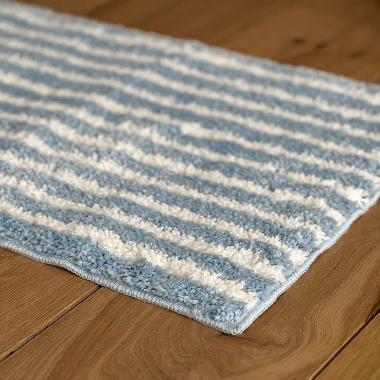 Angled close up showing the thick pile of the blue wavy rug - RoomDen