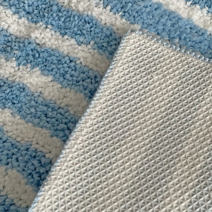 Detail shot of the white geometric non-slip TPR backing on blue rug - RoomDen