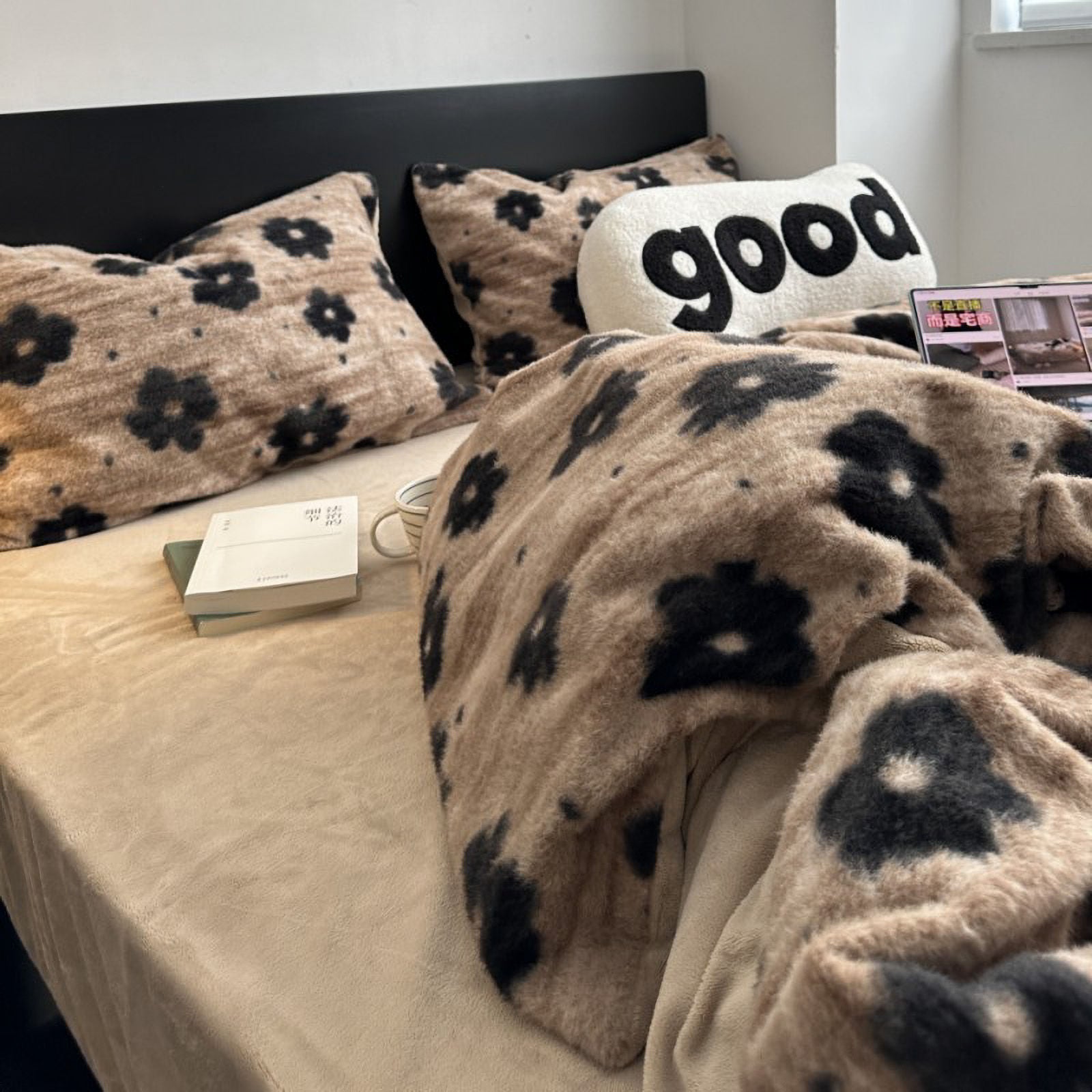 RoomDen plush beige bedding with black floral pattern, cozy dorm aesthetic with books.