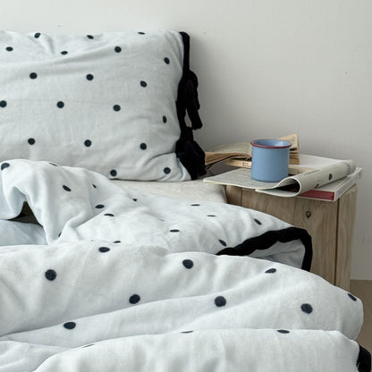 Side view of plush bedding set showing ruffle trim and pillow details RoomDen