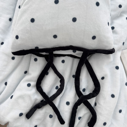 Detail shot of black bow tie closure on cream polka dot pillowcase RoomDen