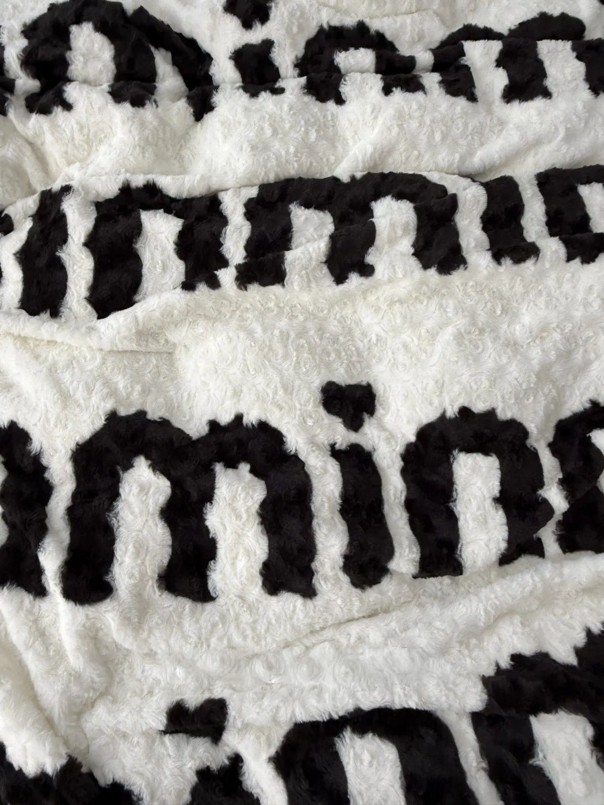Close up texture detail of black and white letter pattern fleece RoomDen