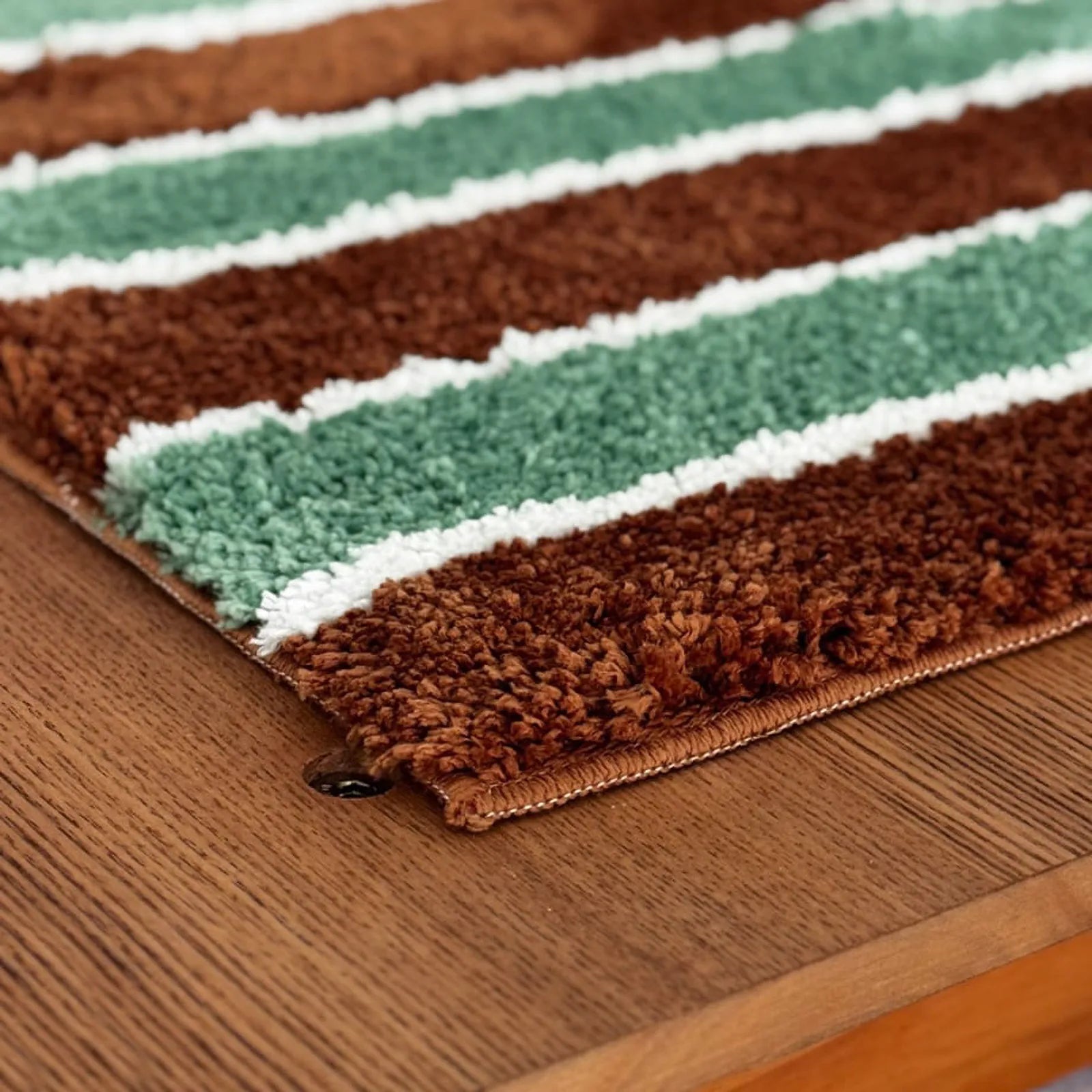 Detail shot showing the high-low pile texture and edge stitching of the retro stripe rug.