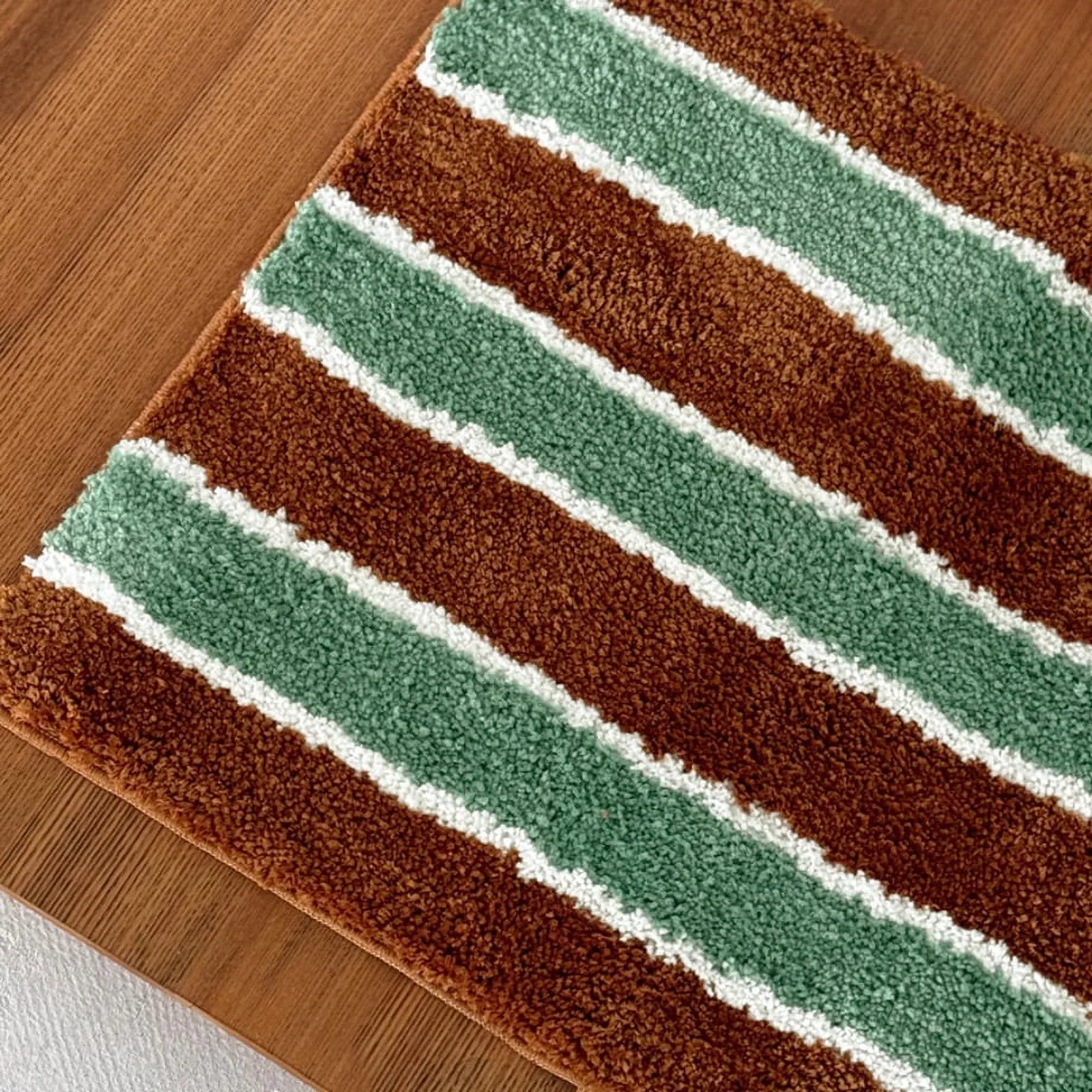 Flat lay of the sage green and rust brown striped rug showing the full pattern.