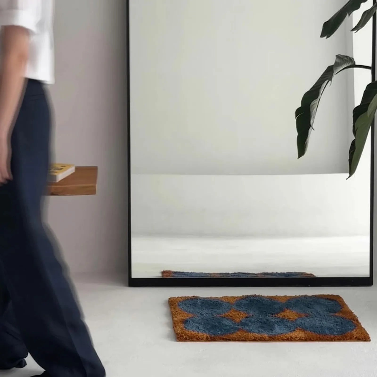 Blurred motion shot of person walking past the rug in a modern room - RoomDen