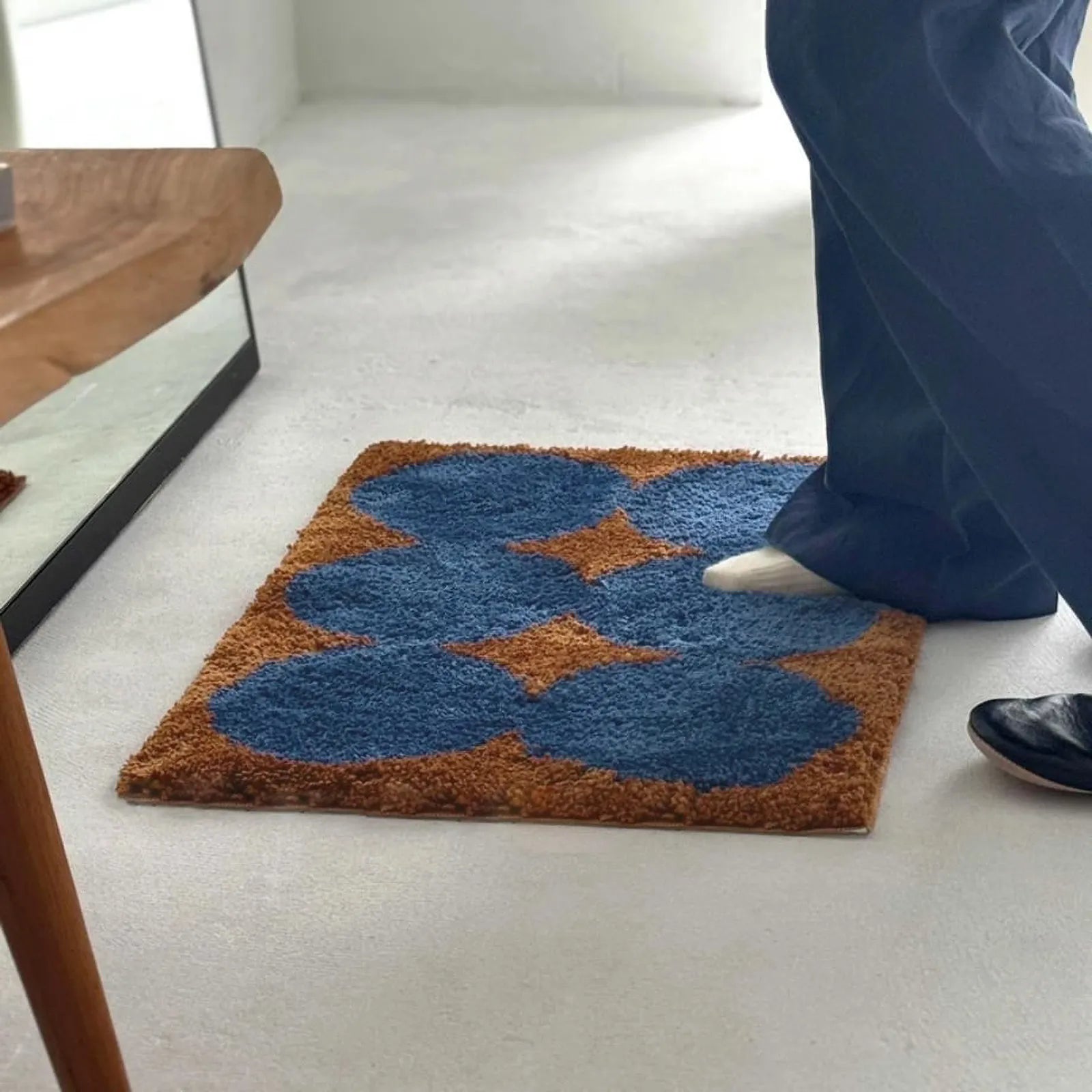 Lifestyle shot of person stepping onto the soft blue and brown tufted rug - RoomDen