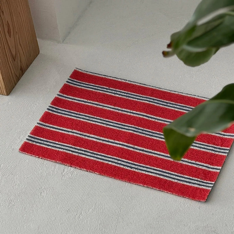 Retro Americana red striped PVC coil rug on a grey concrete floor - RoomDen