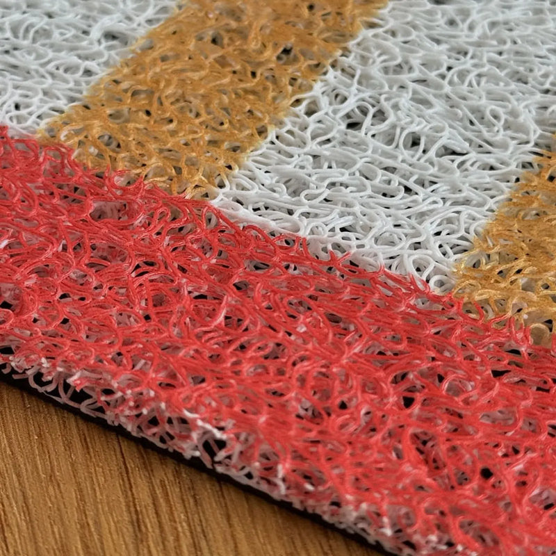 Close-up of the yellow and white loop texture with red border on the coil rug - RoomDen