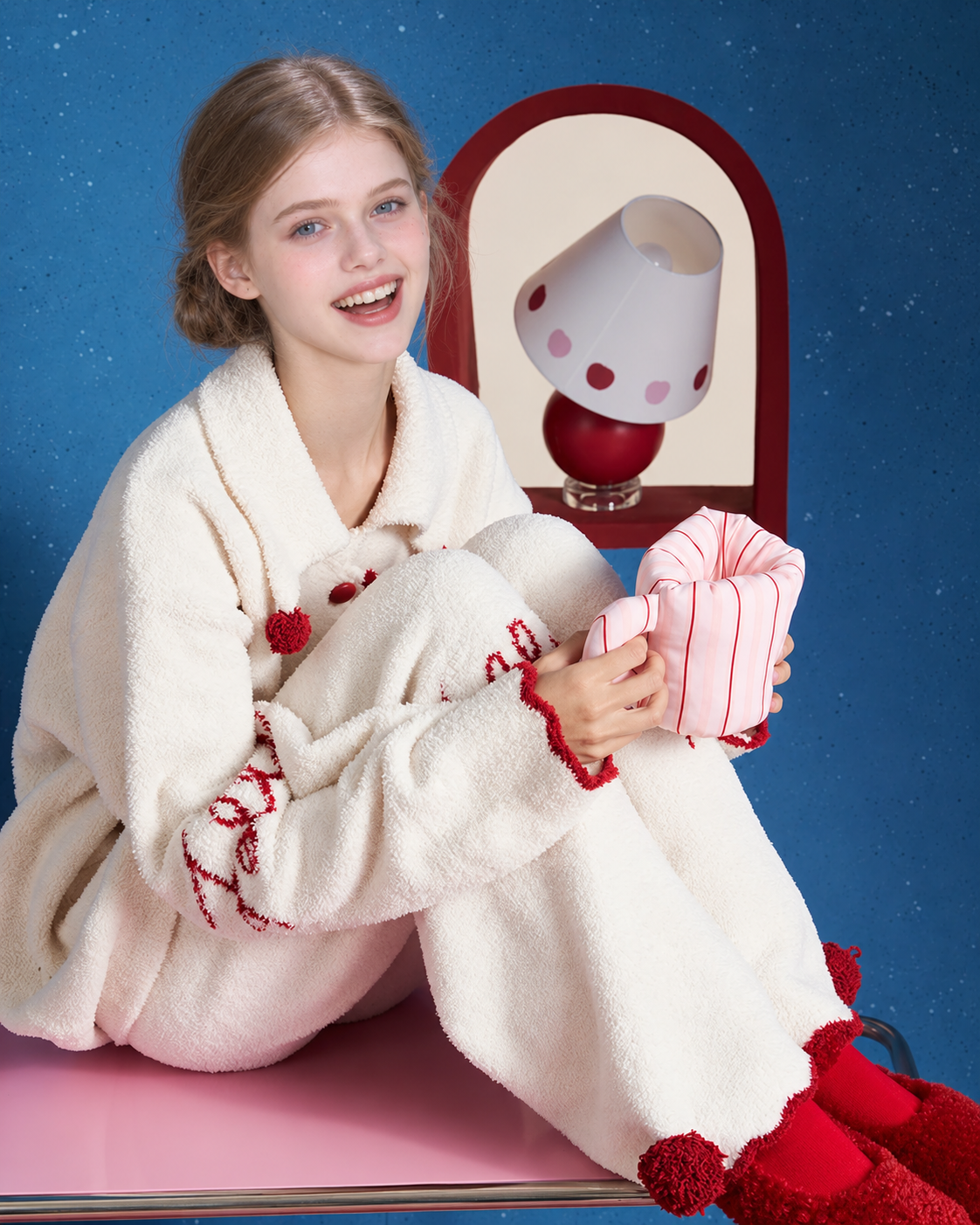 Pom-Pom Fleece Pajama Set – ivory knees-raised seated view with sleeve lettering - Roomden