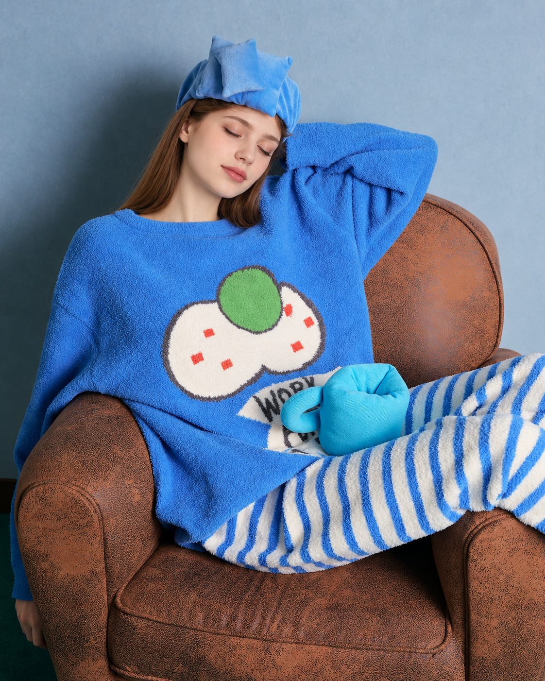 Blue cat graphic fleece pajama set with cream striped pants – Seated in armchair