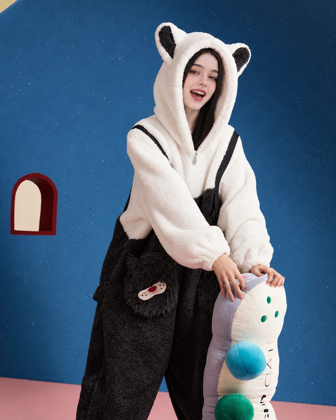 Cat-ear hood and cat-face pocket on black-and-white fleece pajamas with a cushion
