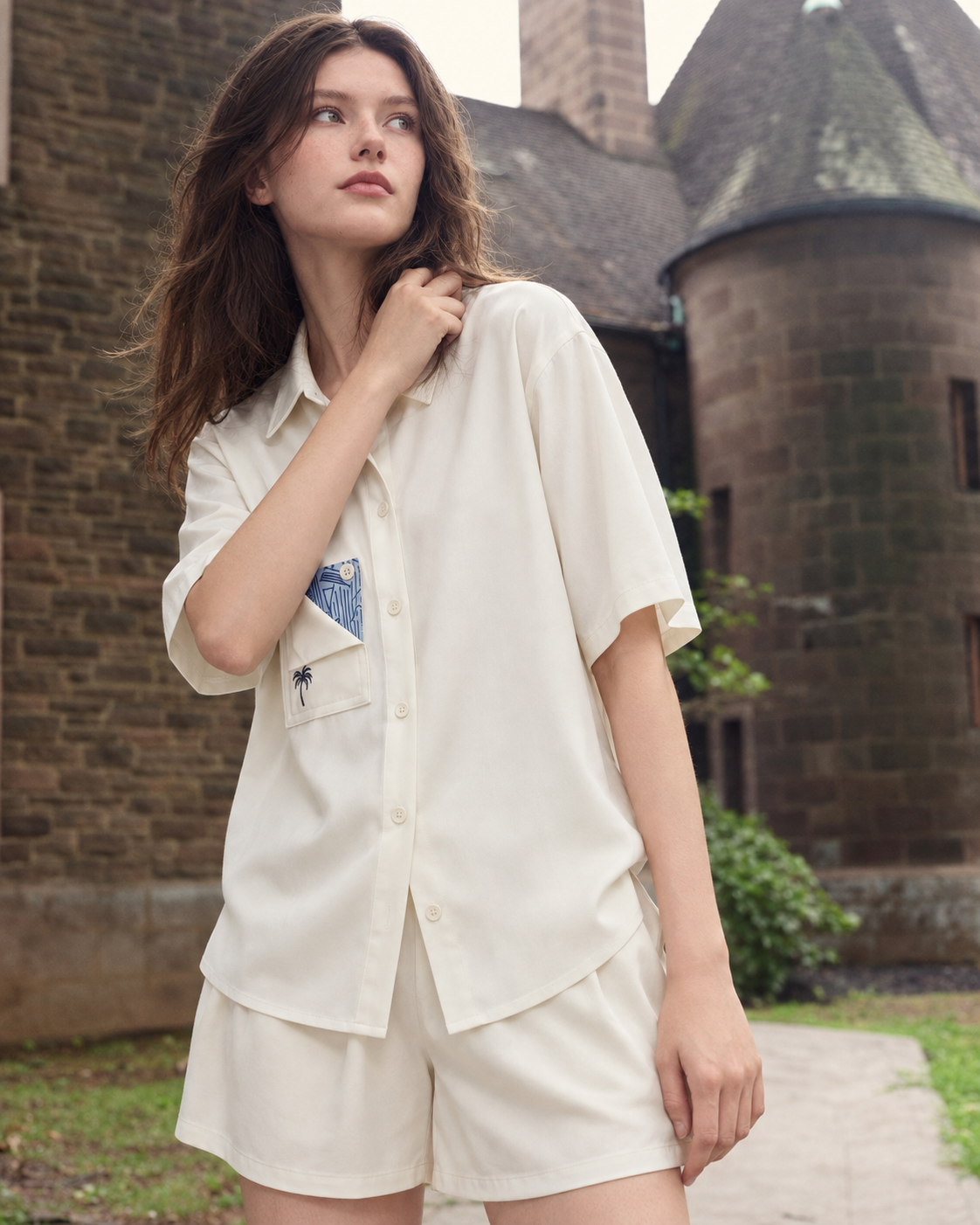 Inkshore Folded-Pocket Viscose Pajama Shorts Set – Cream turned-head portrait beside old stone buildings - Roomden