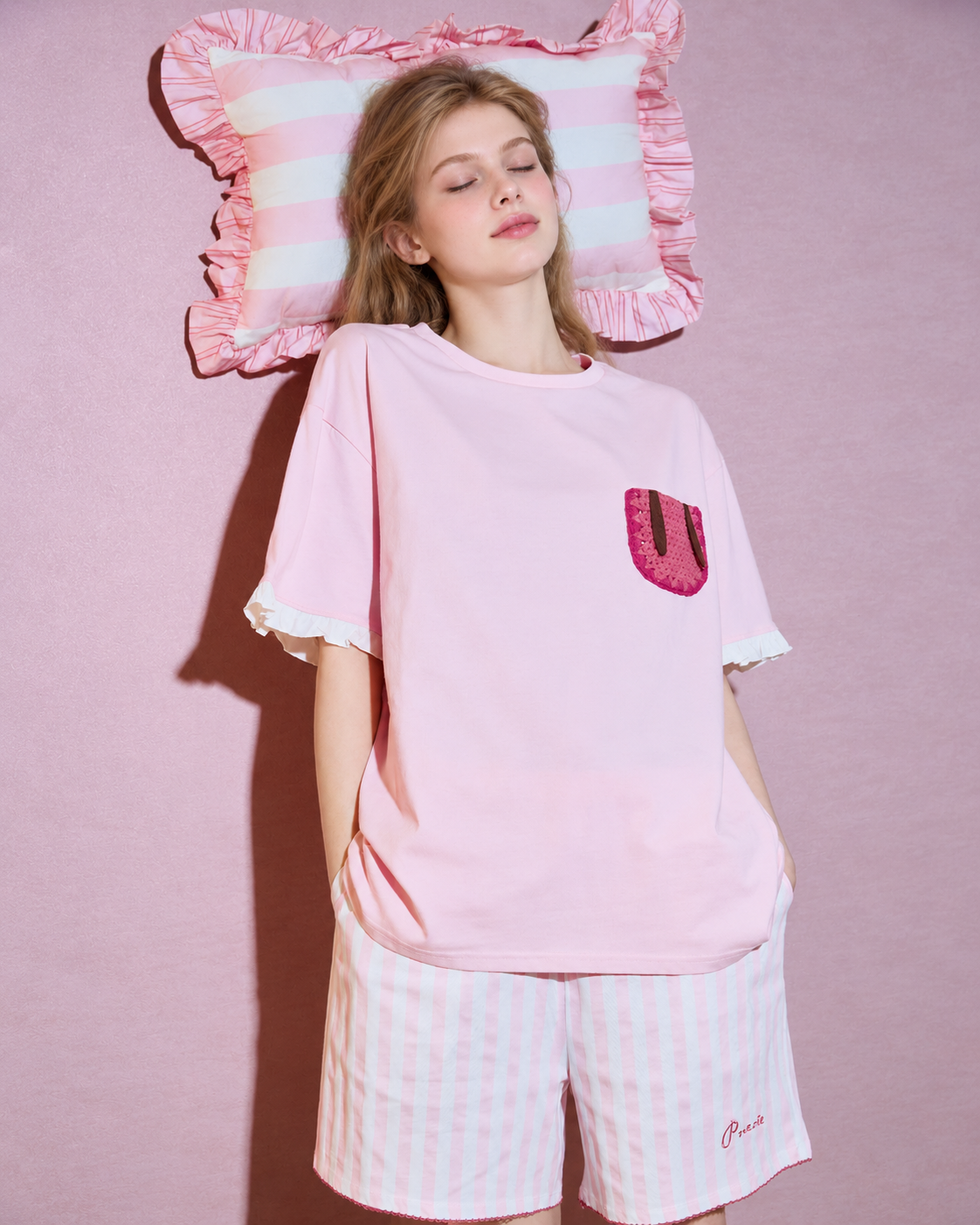 Flopnote Pink Rabbit-Pocket Cotton Pajama Set – front view against a pink wall with a striped pillow prop - Roomden
