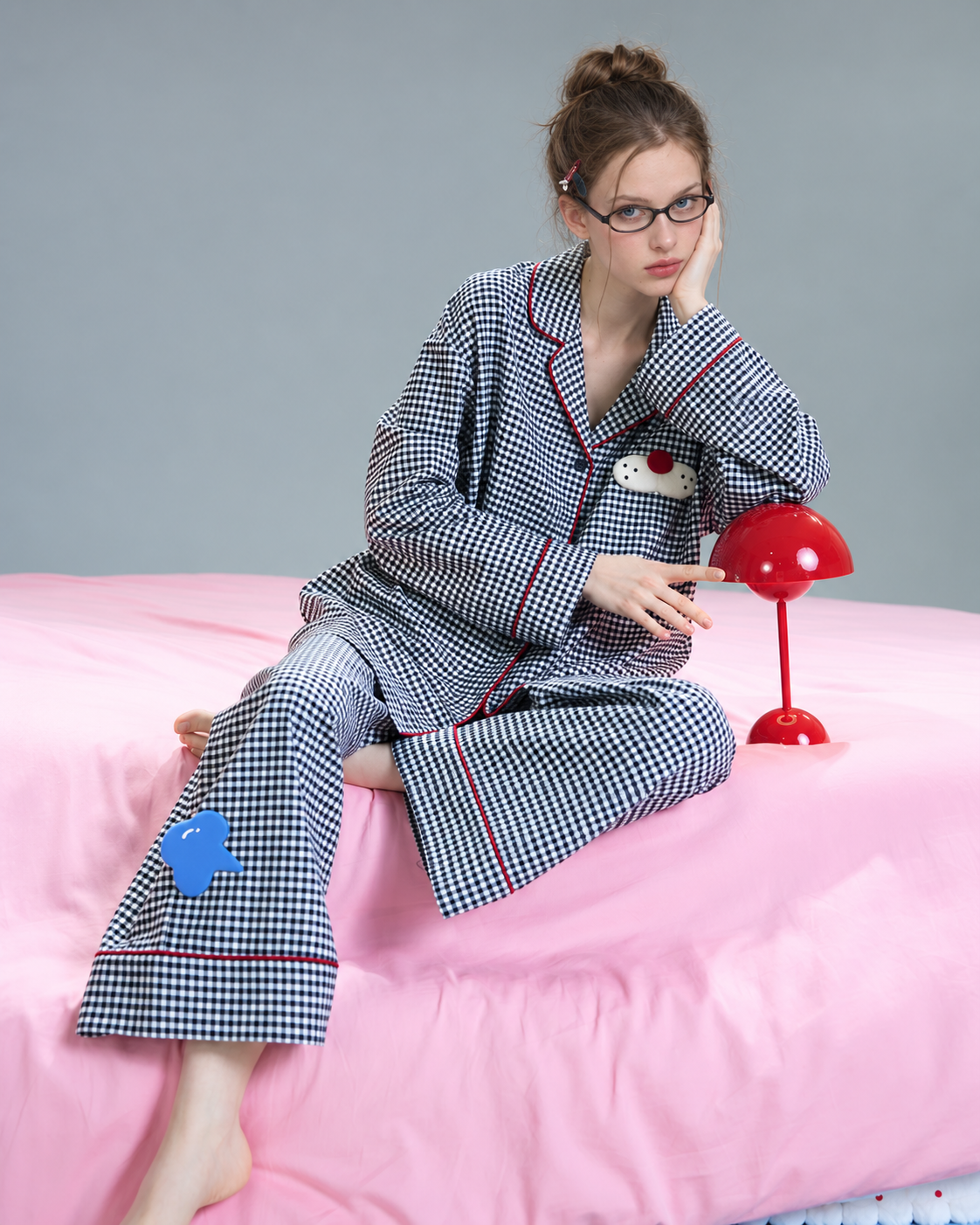 Gingham Cotton Pajama Set – black-and-white checks, seated on a pink bed - Roomden