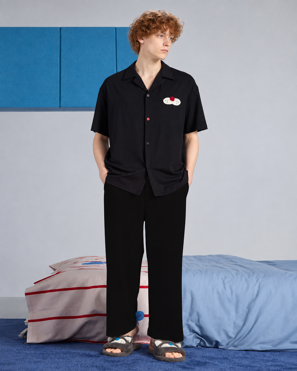 Front view of men's black cotton cat-applique pajama shirt and trousers.