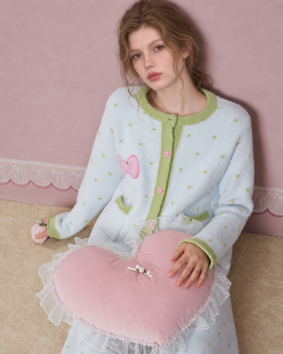 Fleece Three-Piece Pajama Set – Ice blue seated view with a heart cushion on the lap - Roomden