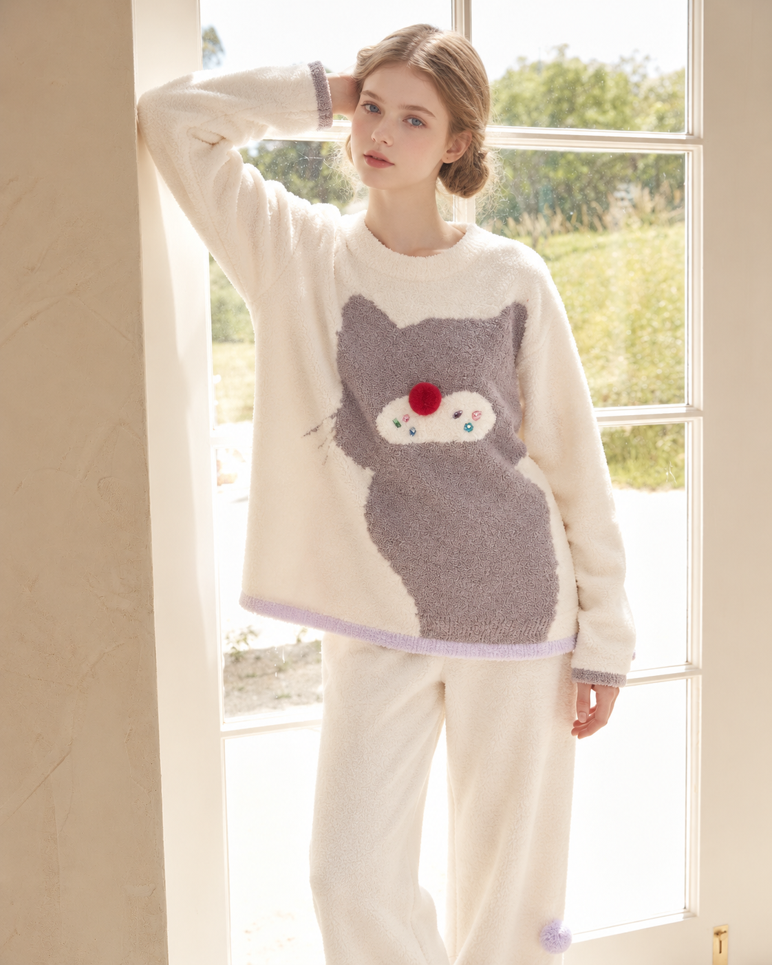 Ivory cat graphic pajama set – window-side raised-arm view of the oversized cat motif - Roomden