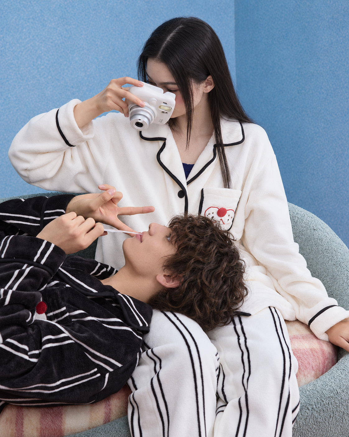 Men's Striped Cat-Pocket Fleece Pajama Set – Black, reclining on a sofa in a camera scene - Roomden