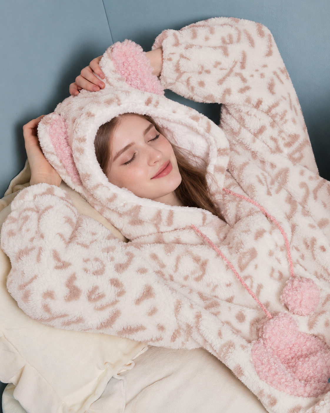 Cat-Ear Leopard Fleece One-Piece Pajamas – cream and pink reclining hood and pom-pom close-up - Roomden