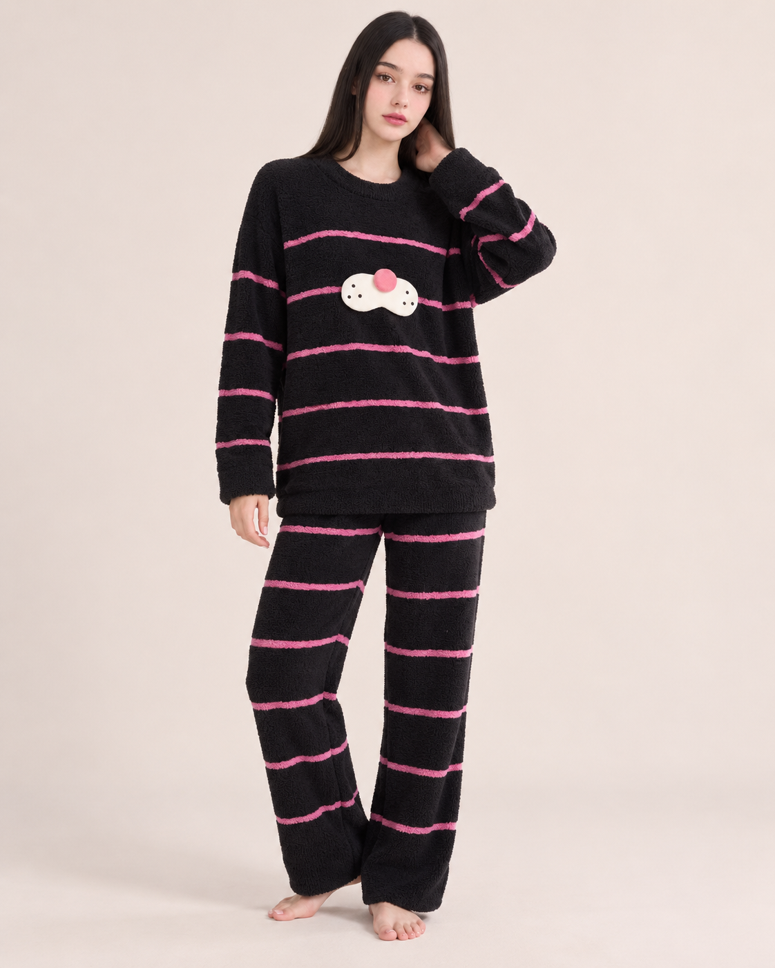 Black striped plush cat pajama set shown on a model in a studio.