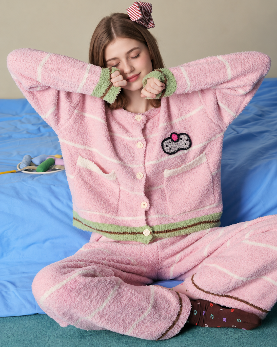 Striped fleece pajama set – peach pink seated on blue cushions with cat motif and patch pockets - Roomden