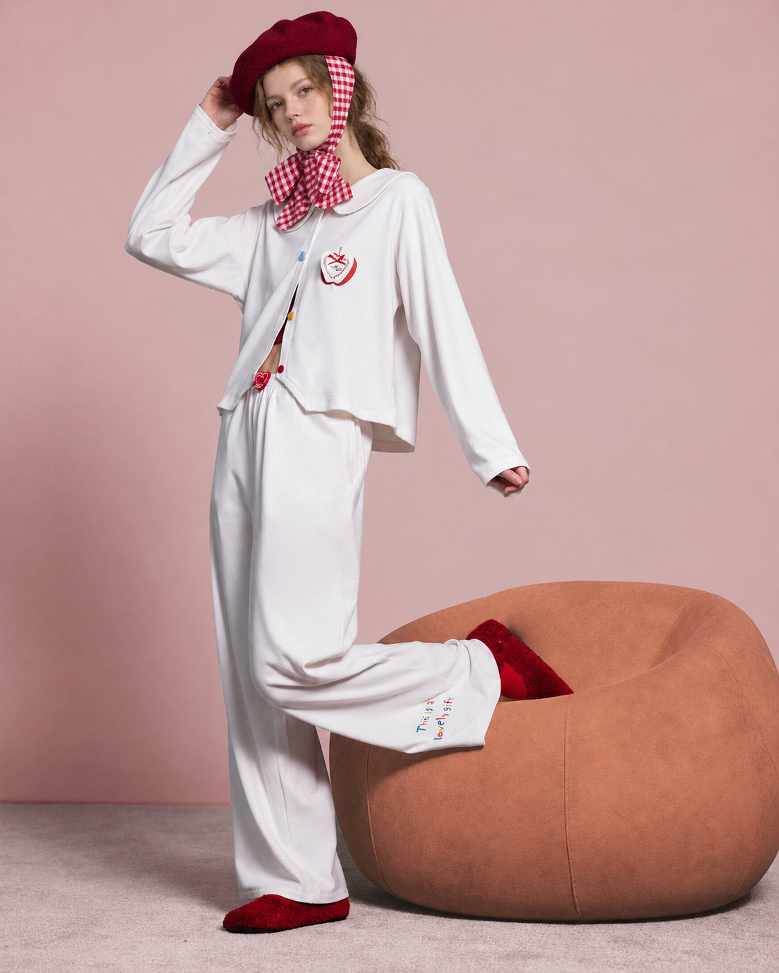 Raised-leg view showing the loose trousers and colorful hem lettering.