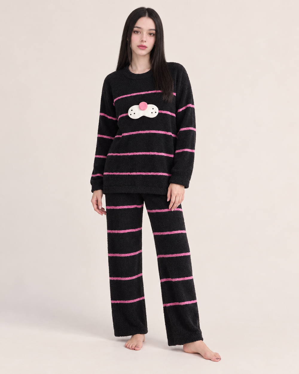 Black striped plush cat pajama set shown on a model in a studio.