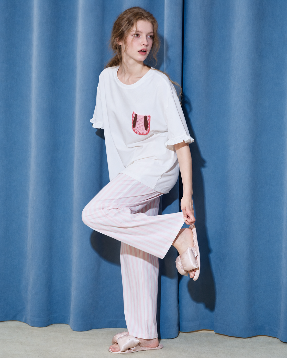 Raised-leg view showing the wide-leg striped trousers