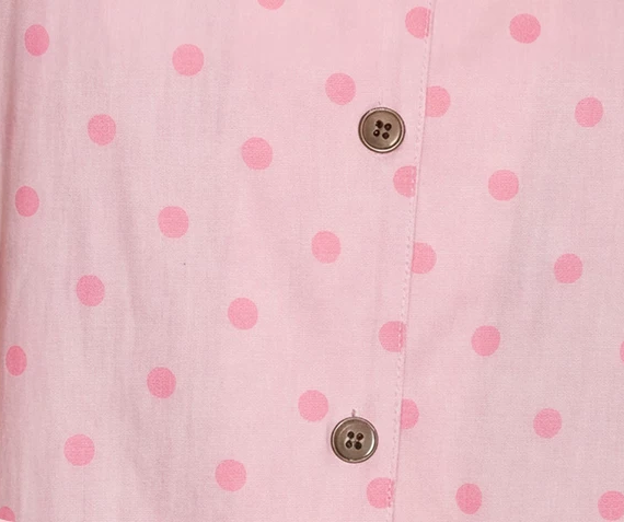 Close-up of pink polka dot double gauze fabric and button