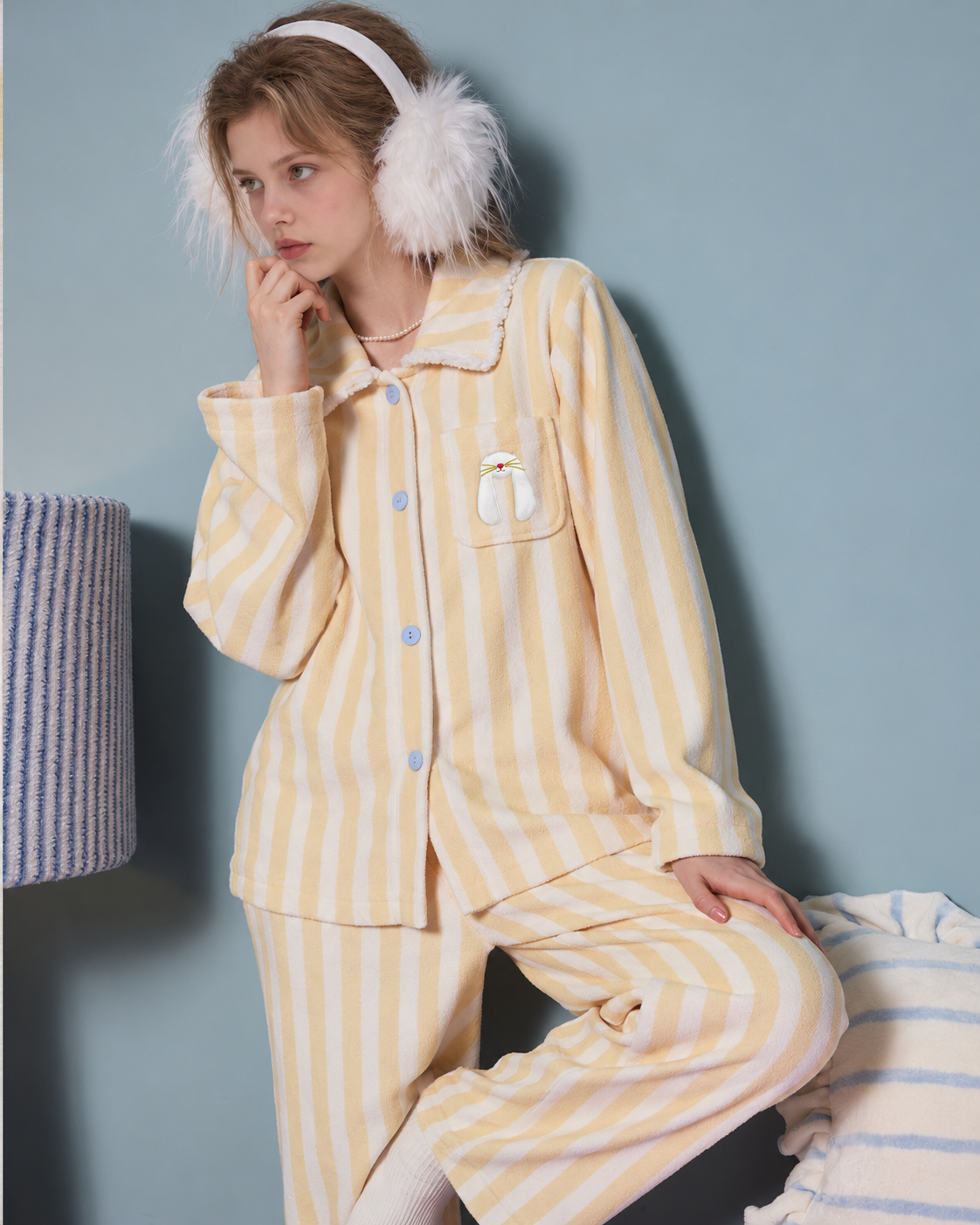 Striped fleece pajama set – bent-knee pose beside a bed and lamp - Roomden