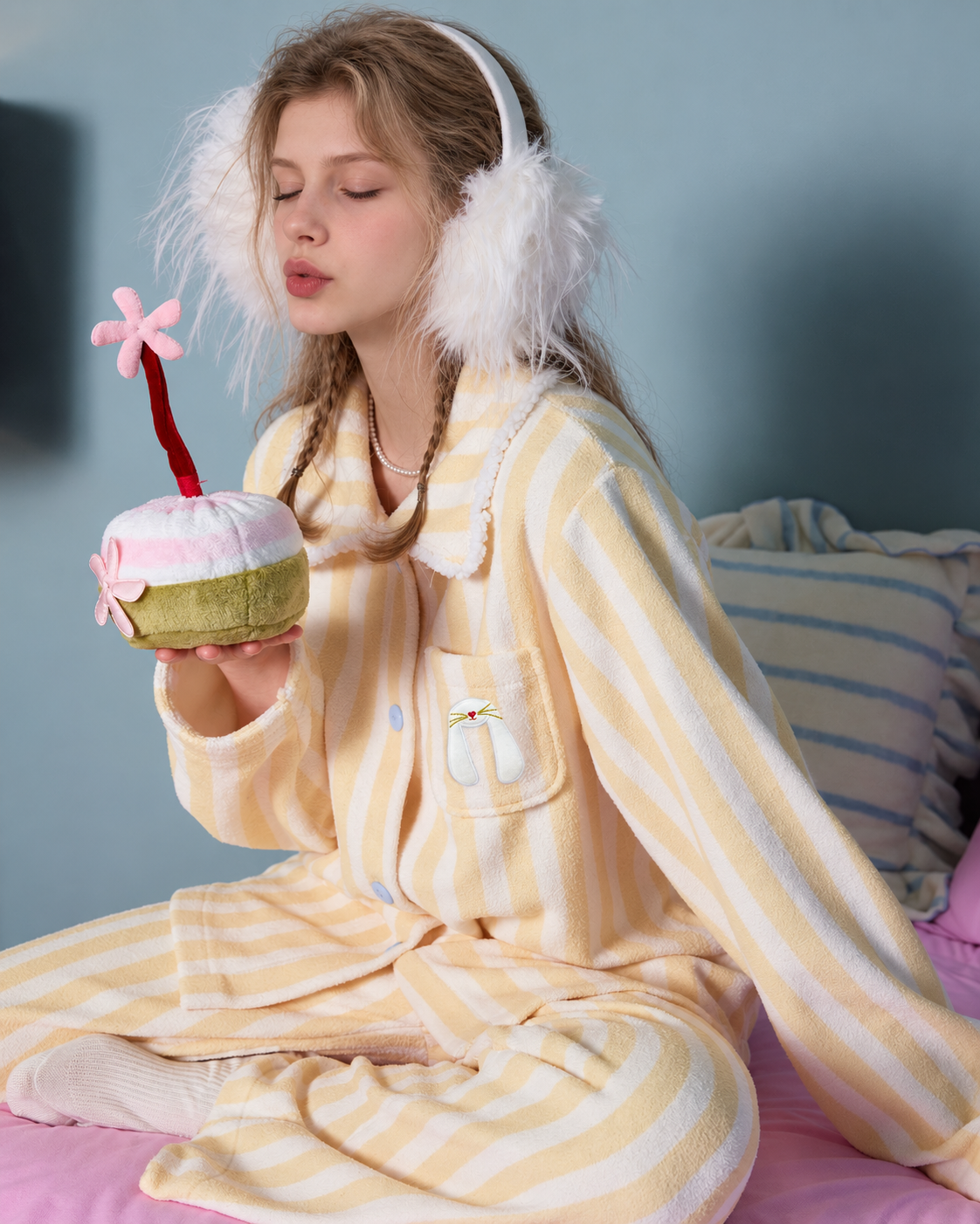 Striped fleece pajama set – seated holding a plush cake with eyes closed - Roomden