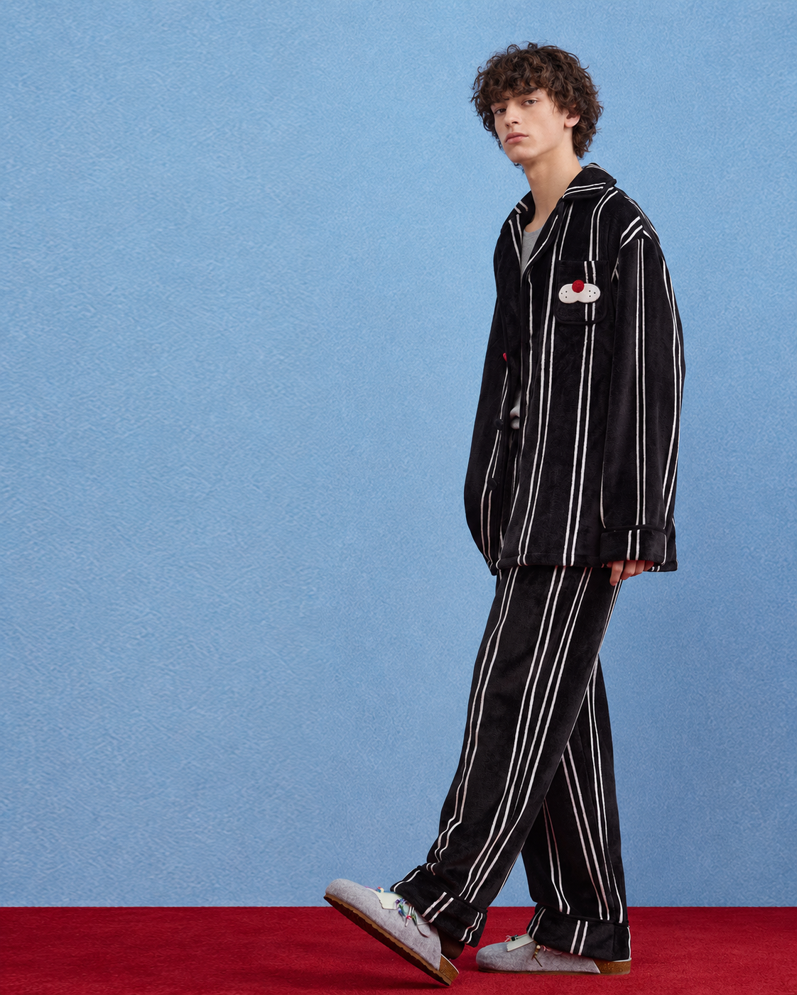 Men's Striped Cat-Pocket Fleece Pajama Set – Black, full-length side view against a blue wall - Roomden