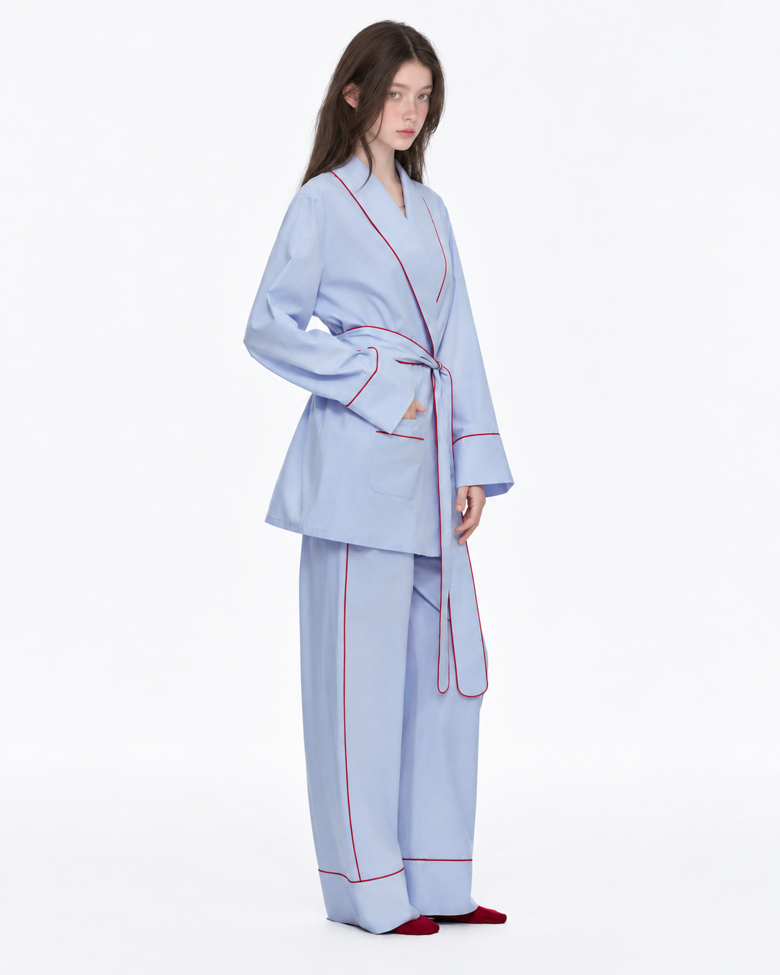 Linehaven wrap pajama set – Baby Blue, side view with a hand in a pocket in the studio - Roomden