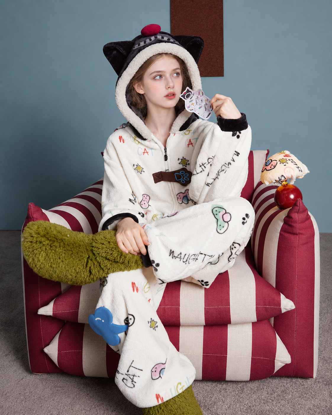 Doodlewhisk Cat-Doodle Hooded One-Piece Pajamas – seated view on a striped chair - Roomden