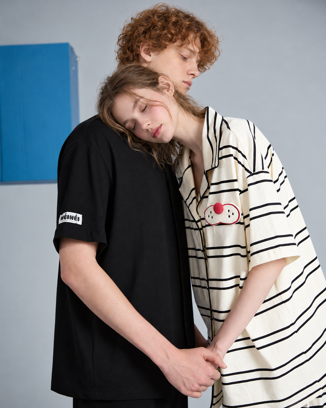 Close view of the black men's pajama shirt beside a companion in striped pajamas.